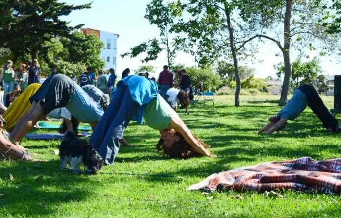 People do yoga in a park